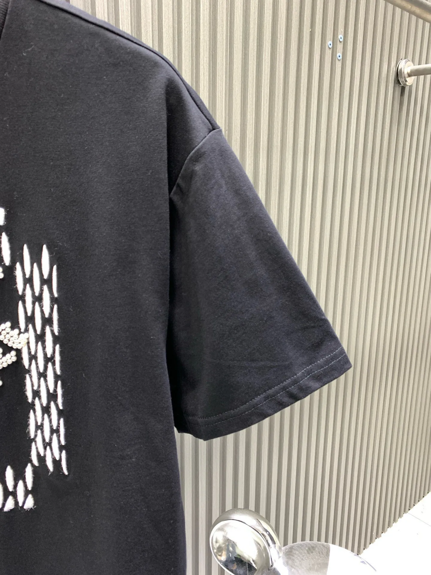 🅿️280 🀄️ Louis Vuitton Louis Vuitton 1V Louis Vuitton 2025FW The most expensive embroidered/pearl beaded half-sleeved T-shirt in history. This cotton T-shirt is from the 2025 spring and summer show. It shows the latest designer Pharrell Williams/Fei Dong's Marque L. Vuitton déposée logo created by citing the brand archives. Beaded embroidery and delicate silk threads highlight the dandy theme of the season. The reverse-effect beaded embroidered label injects a trendy look into the casual look. The fabric is made of 40s double-ply combed cotton + long-staple cotton blended compact siro-spun yarn. The weight is 280g. The front panel is embroidered with Tajima embroidery machine imported from Japan. Thick rubber pad base polyester mercerized three-dimensional hemming embroidery. Each bead is hand-pointed. A cardboard mold is opened. A single cut piece is powder-swept for precise positioning. The beads are made with 4-mile round pearlescent white bubble beads and are hand-crocheted. All single beads are tied with hooks and threads to ensure they are in the right position to sweep the powder, which is different from the ordinary beaded versions on the market.